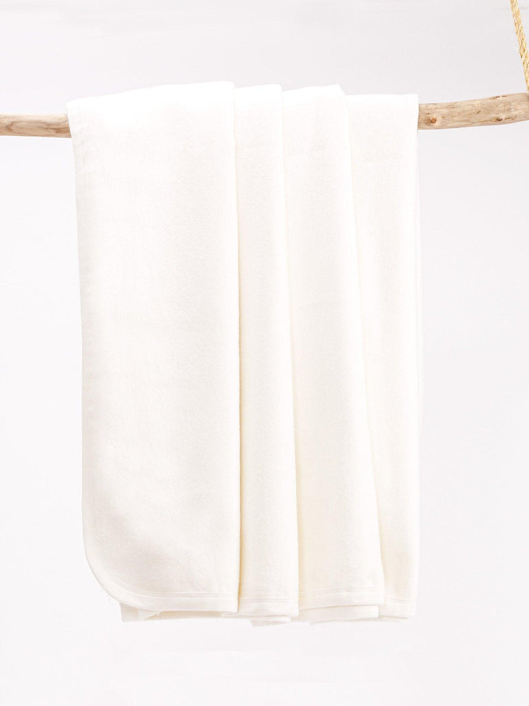 organic fleece blanket draped over wooden hanger.
