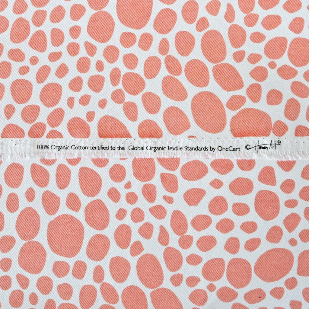 close up of organic cotton fabric in coral and white